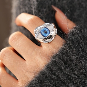 Macro view of irregular silver ring featuring a realistic blue resin eye and melted texture