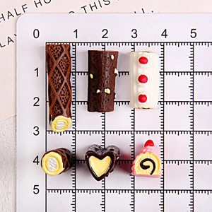 Vue détaillée de charmes de dessert assortis en résine chocolat et fraise sur une grille