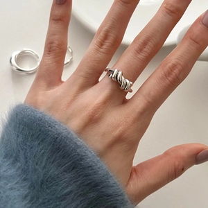 Close-up of 925 sterling silver knot ring featuring a polished minimalist twist design