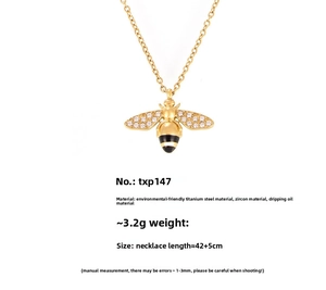 Detail of gold bee necklace featuring white zircon wings and black enamel stripes on a thin chain