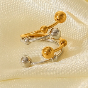 Two-tone stainless steel spiral ring with gold and silver spheres on yellow silk