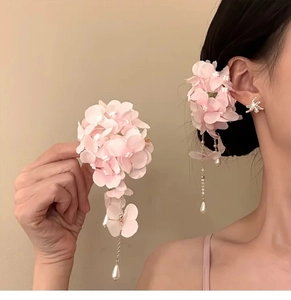 Detail of pink fabric flower hair clip with metal tassels and white teardrop pearls