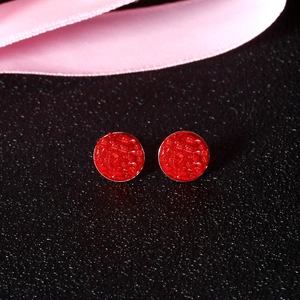 Macro shot of red round crystal cluster studs with S925 silver frame on black leather
