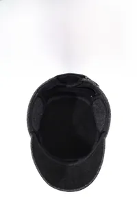 Detail view of winter flat cap for men with warm ear flaps and thick wool texture