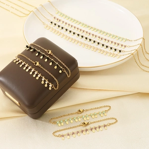 Elegant gold chain jewelry set with colorful beads and teardrop pendants in a box