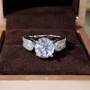 Close-up of a classic four-prong round zircon engagement ring in a brown velvet box