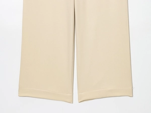 Détail de l'ourlet droit et de la texture sergée fine sur ce pantalon large beige