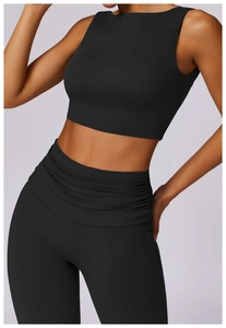 Detail of high-waist yoga leggings with unique ruched overlap design in black fabric