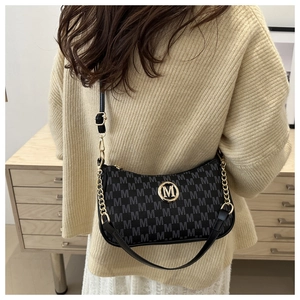 Detail of crescent shoulder bag with monogram print and gold metal logo on model