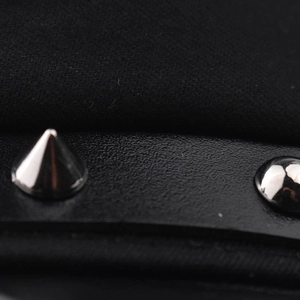 Dettaglio del berretto militare nero con cinturino in pelle e borchie in metallo argento