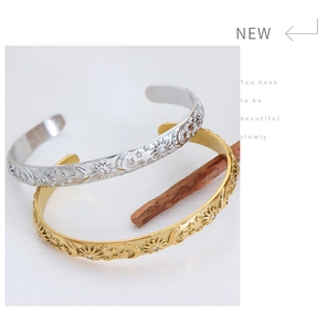 Detailed macro of gold and silver sun and moon embossed bangles with rhinestone details