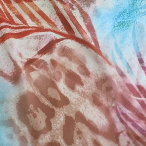 Macro detail of silky leopard and floral print fabric showing soft texture and drape