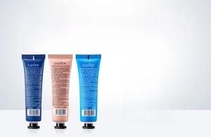 Detail van drie 30g handcrèmes in blauwe en roze verpakking met vruchtenextracten