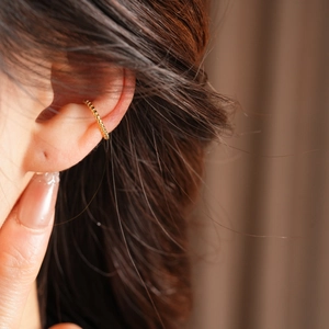 Detailed view of 18k gold plated ear cuff featuring textured beaded pattern and sleek finish