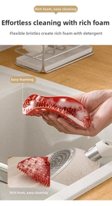 Close-up of flexible red silicone brush generating rich white foam for efficient cleaning