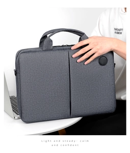 Detailed view of gray fabric laptop bag with front pocket and sturdy handle design