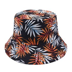 Detailed view of bucket hat with orange and white palm leaf prints on black fabric