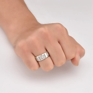 Detail of men's matte brushed steel ring with three channel-set square white stones