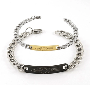 Détail de bracelets de couple en acier inoxydable avec plaques gravées cœur et flèche