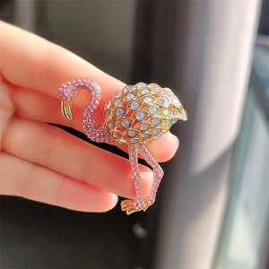 Detailed close-up of a flamingo brooch with pink rhinestones and iridescent stones
