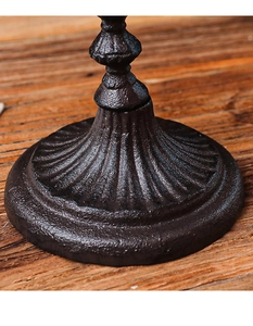 Macro detail of vintage cast iron candle holder base with textured brown finish