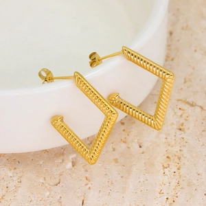 Minimalist geometric gold rhombus earrings with twisted rope texture on a white bowl