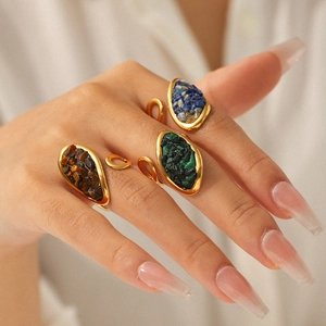 Detail of adjustable gold-plated rings with natural tiger eye and malachite gemstones