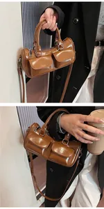 Detail of glossy brown barrel saddle bag with dual front pockets and top handle