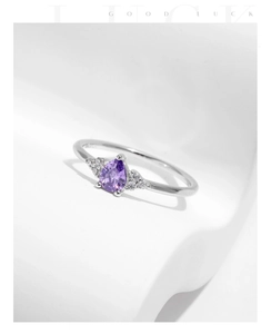 Macro detail of S925 silver ring featuring a pear-cut purple crystal and accent stones
