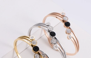 Detail of triple-layer bangle in gold, silver, and rose gold with pavé rhinestone accents