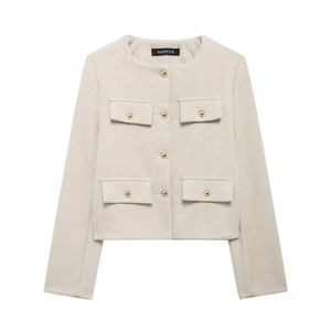 Détails d'une veste en tweed crème montrant le tissage et les boutons dorés