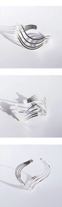 Detailed views of silver multi-layered wavy open cuff bracelet with minimalist line design