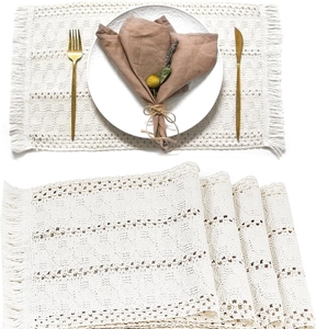 Detail of stacked boho woven cotton placemats with fringe edge for wedding table decor