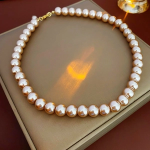 Close-up of champagne gold pearl necklace on a premium jewelry box under warm lighting