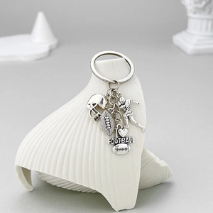 Antique silver American football keychain with player, helmet, ball and heart charm