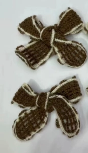 Close-up of handmade brown knitted bows with white trim for DIY clothing and accessories