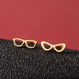 Minimalist gold sunglasses-shaped stainless steel stud earrings on red backdrop
