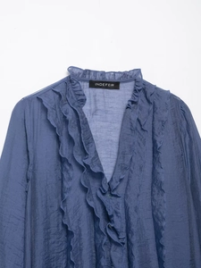Detail van blauw ruig shirt met elegante geplooide textuur en kraag met ruches afwerking