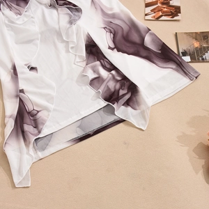 Detailed view of the wavy ruffled hem with purple ink texture on lightweight white mesh fabric