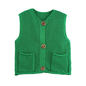 Close-up of chunky knit green vest featuring vintage resin buttons and front pockets
