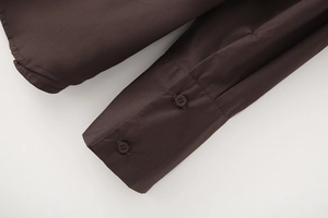 Detail view of dark brown poplin shirt cuffs featuring matching double button closure