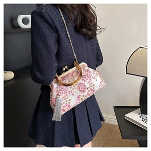 Detail of pink floral embroidery bag with bamboo handle and elegant grey tassel charm