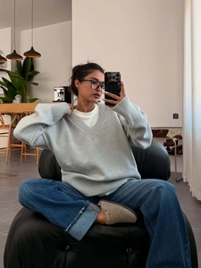 Light grey V-neck knit sweater with drop shoulder design in a stylish mirror selfie