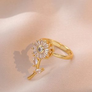 Rotating golden sunflower ring with sparkling zircons on elegant beige silk fabric