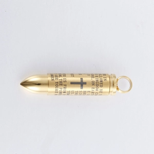Detail of gold bullet pendant with cross engraving and engraved Lord's Prayer text