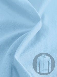 Detailed texture of light blue linen-cotton fabric on a men's casual long-sleeved shirt