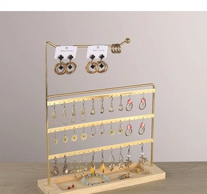 Detailed view of golden iron earring stand with multi-layer holes and wooden base tray