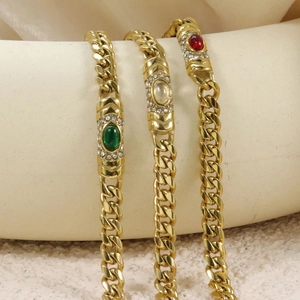 Retro Cuban link bracelets in gold with emerald, ruby, and crystal oval stones