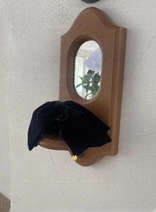 Detail einer großen schwarzen Samtschleife-Haarklammer mit kleinem goldenen Metallanhänger