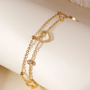 Close-up of double-layer 18K gold plated steel bracelet with hollow heart and zircon